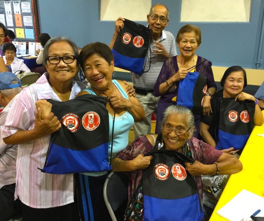 Older adults hold up emergency Go Bags gifted them by MySafe:LA
